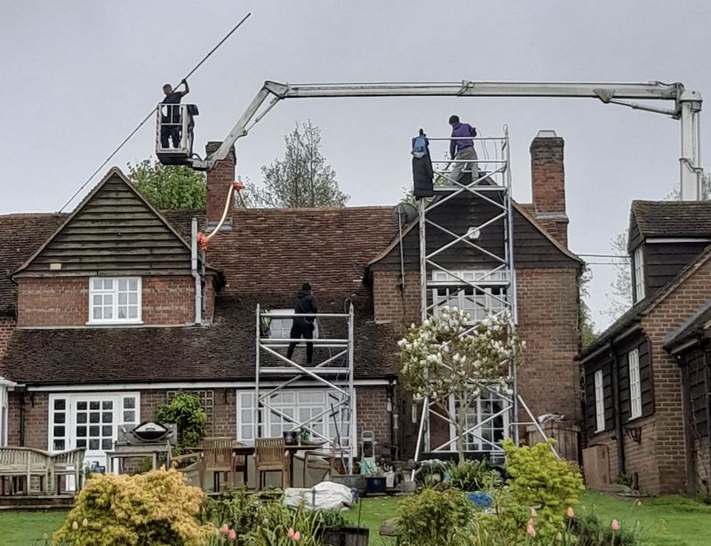 The Roof Moss Cleaners using cherry picker and scaffolding to clean roof safely and professionally in Liss, Hampshire